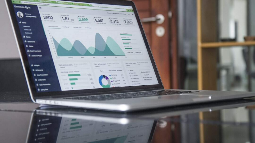A businessperson looking at a laptop with a graph showing the success of technical SEO
